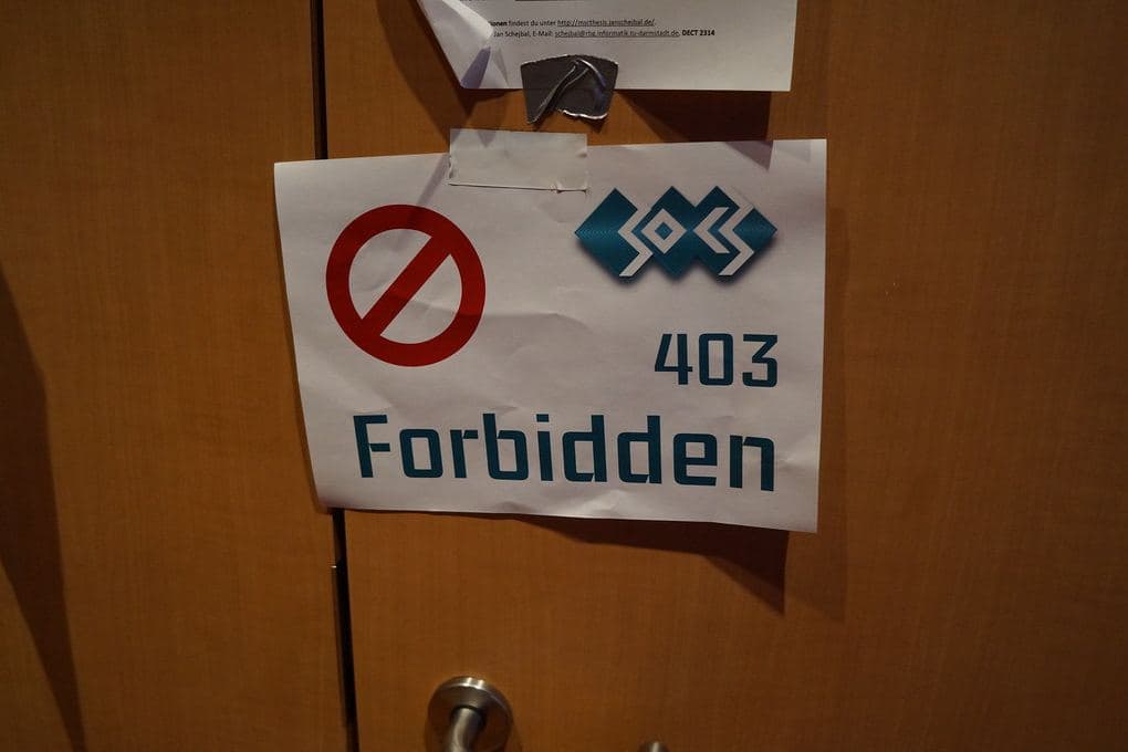 A paper sign reading “403 Forbidden” taped to a door