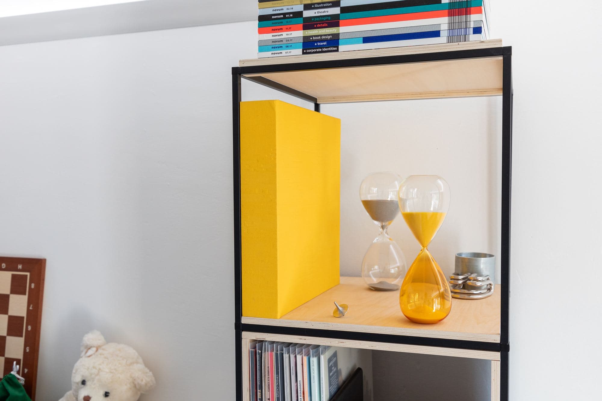 A yellow hourglass on a shelf