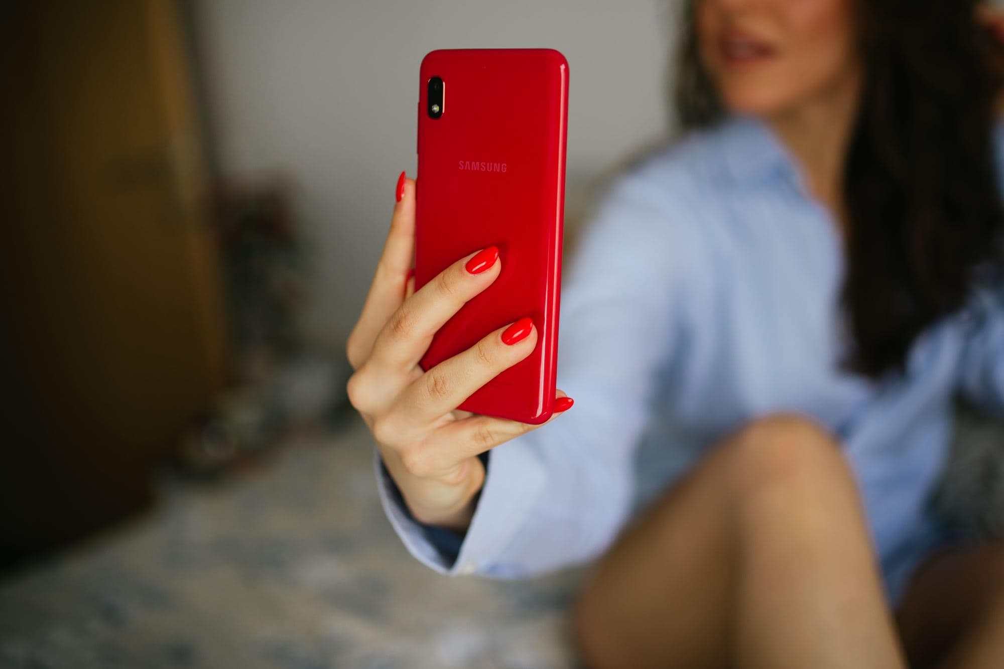 A woman holds her phone up to take a selfie