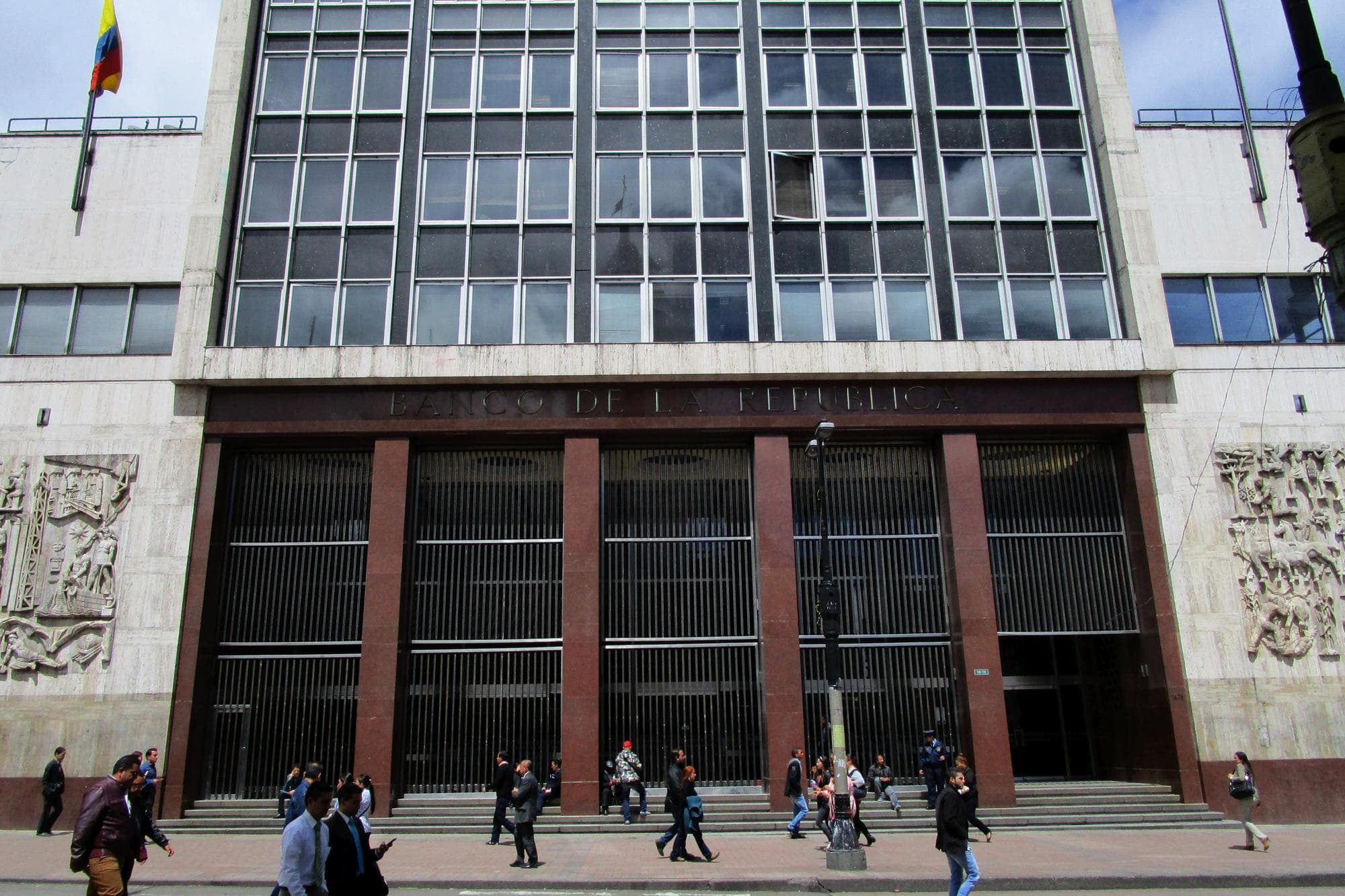 The façade of the Banco de la República in Bogotá, with people walking past
