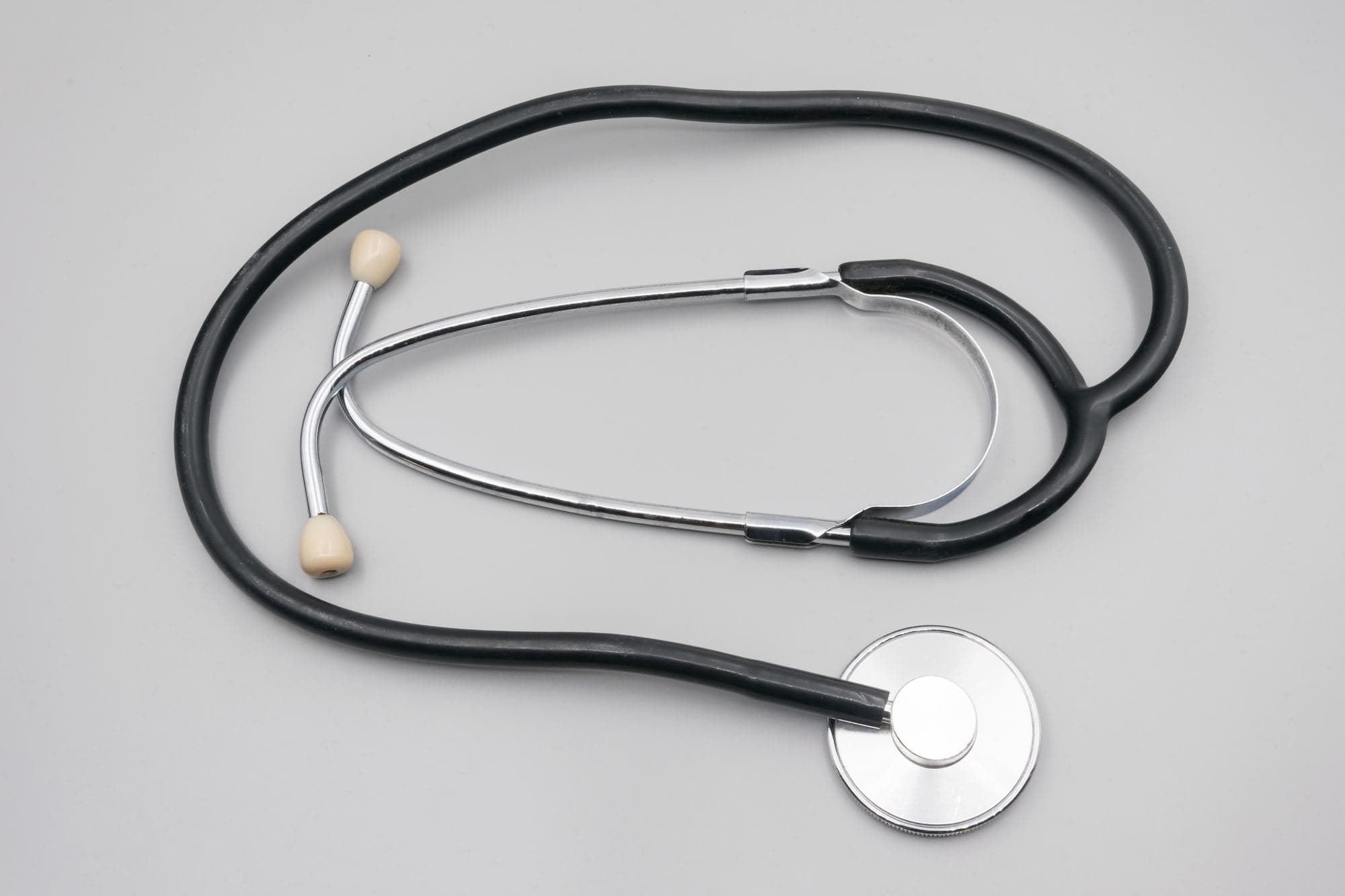 A black stethoscope on a grey background
