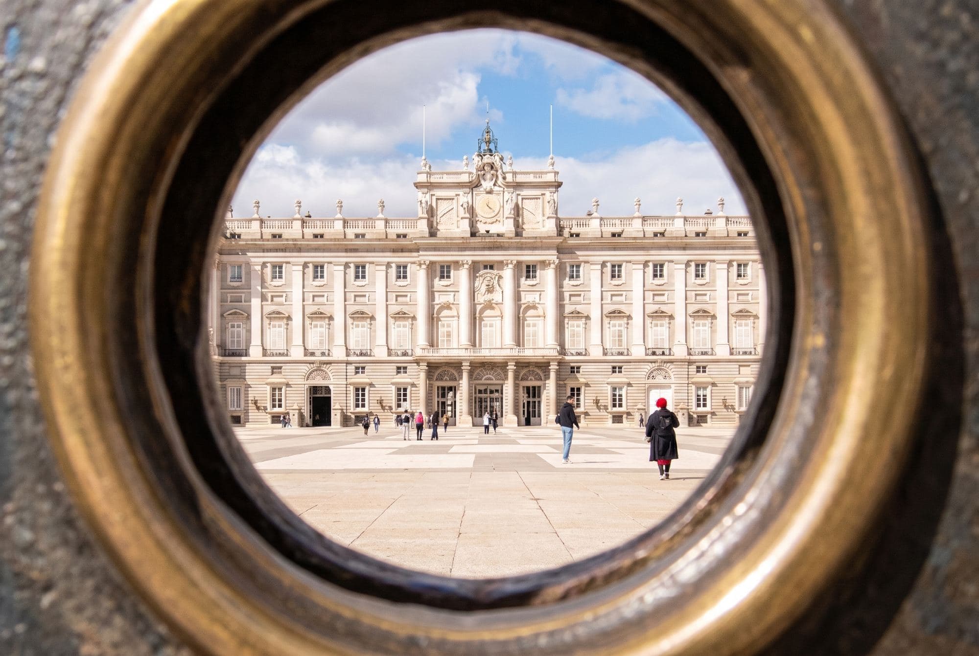The Royal Palace in Madrid seen through a round, gold-coloured iron railing