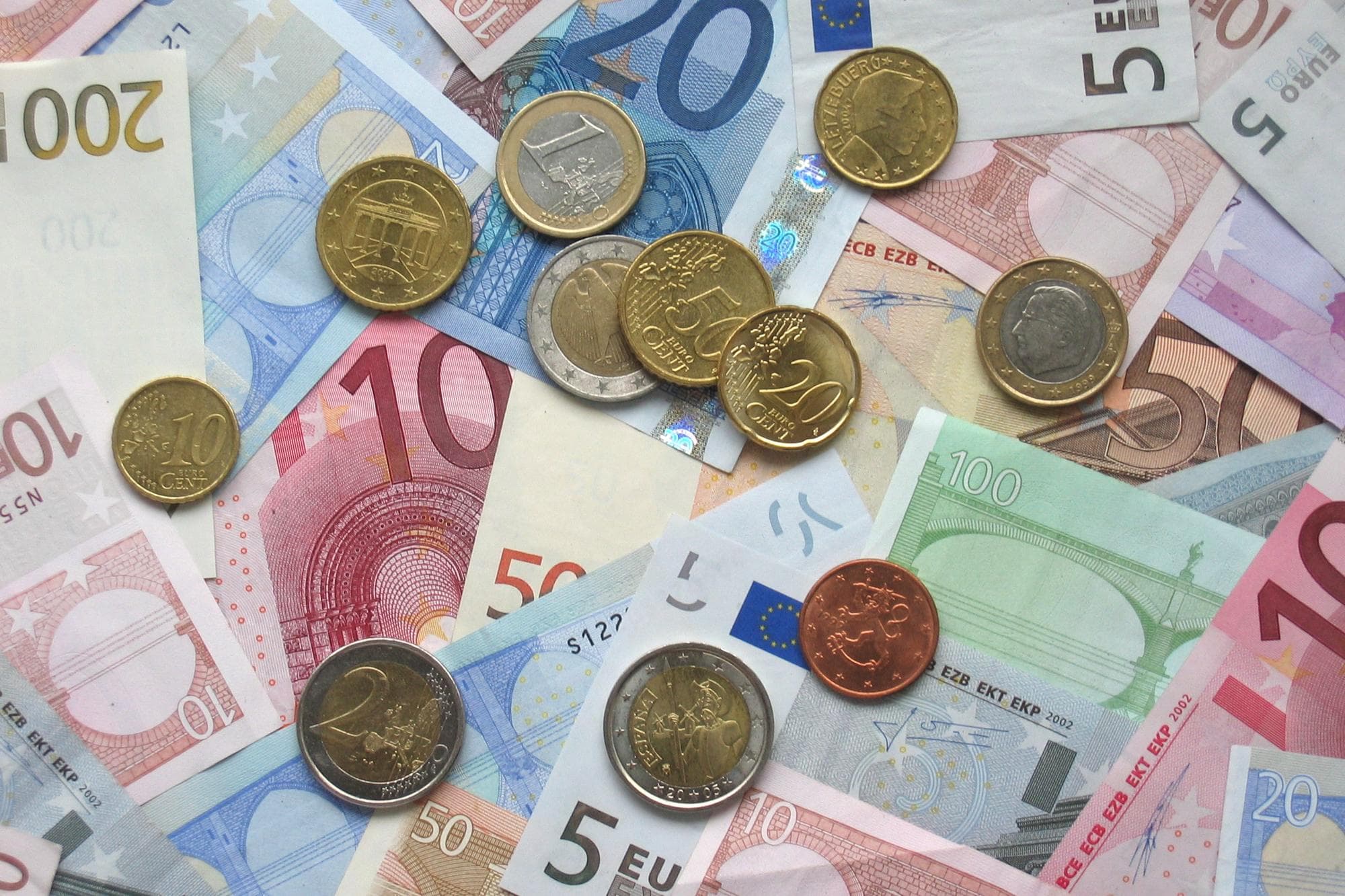 Euro coins and banknotes spread out on a table