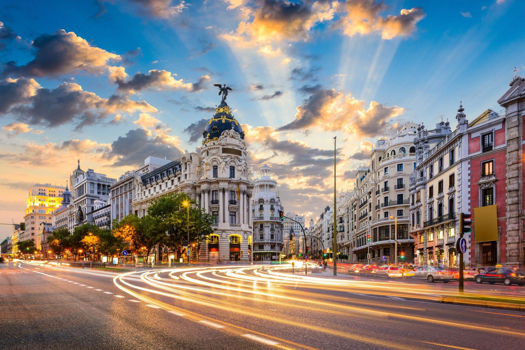 Madrid's Gran Vía at dusk, with the Metrópolis building in the background