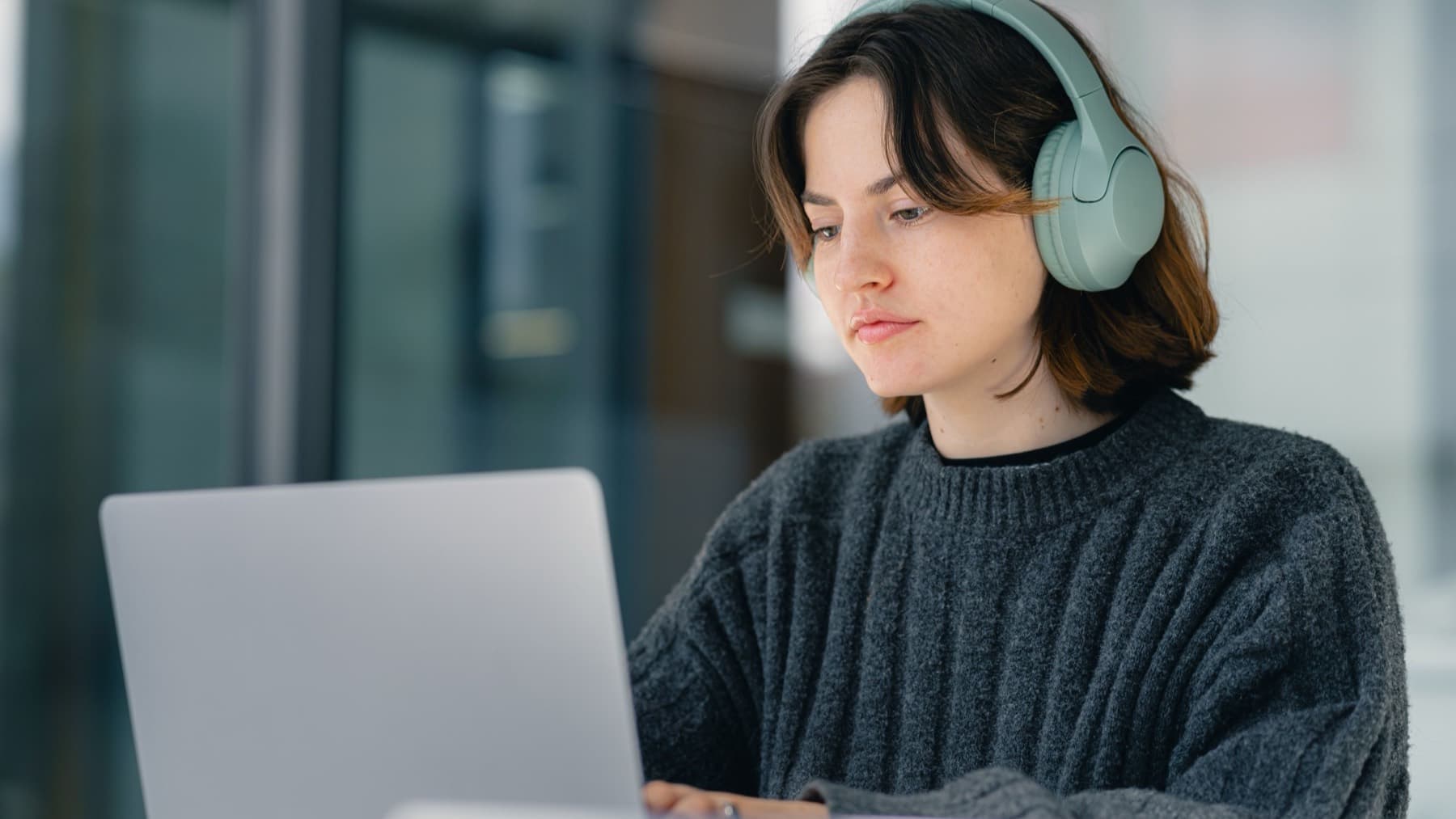 Remote professional working on her laptop with headphones