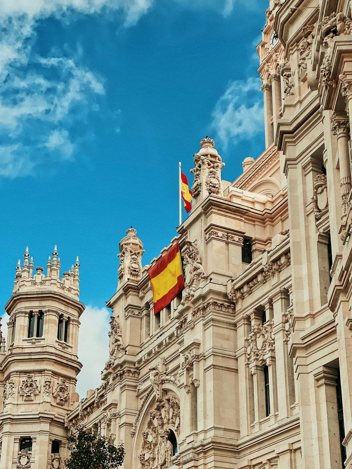 A historic building with a Spanish flag under a blue sky